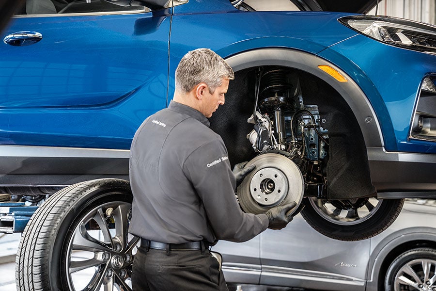 Certified Service technician working on a brake rotor with the vehicle wheel removed