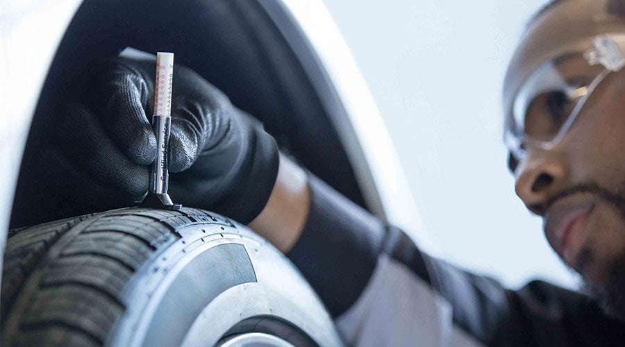 Chevrolet service technician checking tire tread in Washington PA